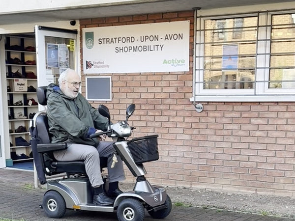 Dhougal on a mobility scooter outside Stratford-upon-Avon Shopmobility